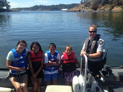 First Nations Community RCMP officer with children on a boat