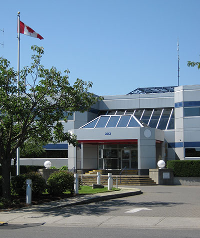 Nanaimo detachment viewed from the street, with a Canadian flag flying overhead.