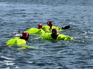 Jeunes portant de l’équipement de survie flottant dans l’océan