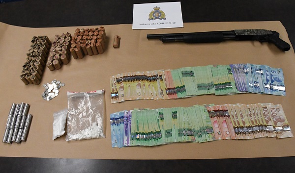 Drugs, shotgun and cash displayed on table